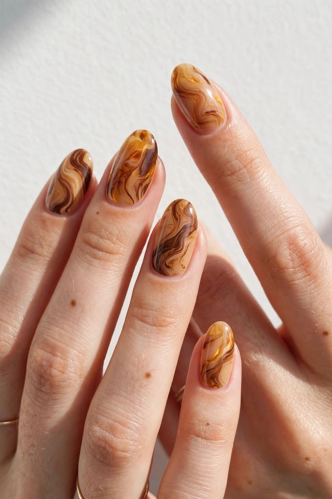 caramel marble oval nail design with clean-edged touches on oval nails in pale tones, chestnut and honey